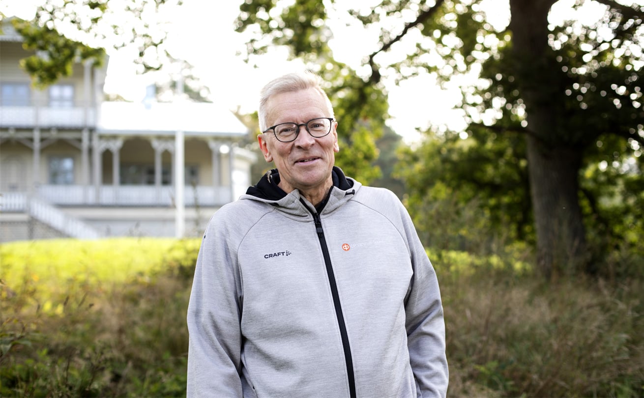 Petteri Rinne seisoo ulkona harmaa huppari päällään. Taustalla näkyy pitsihuvilan veranta.