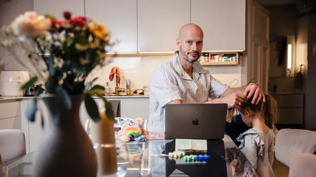 Kim Herold istuu kotinsa keittiöpöydän ääressä ja laittaa lapselleen saparoa kuntoon.