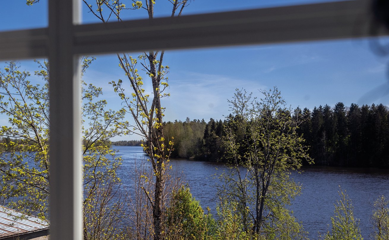 Ikkunasta näkyvä leveä jokimaisema.
