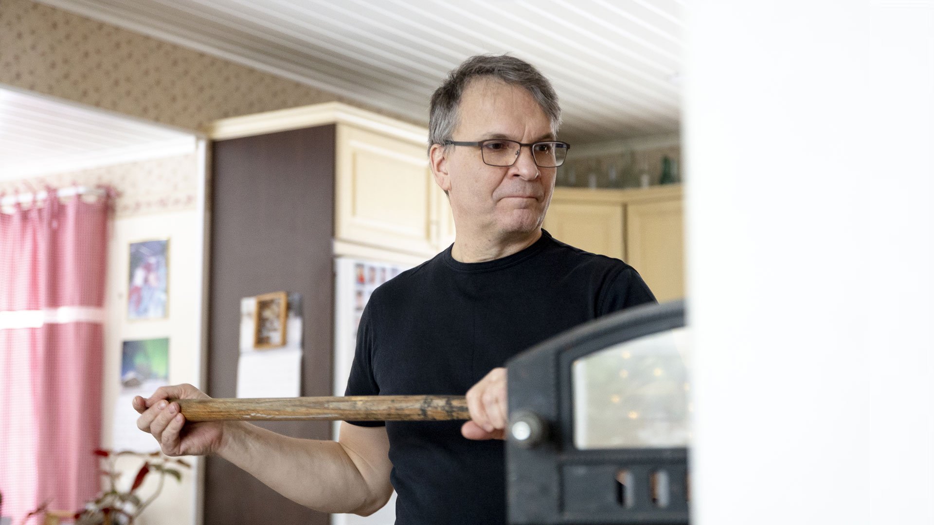 Heino Vanhala paistaa leipää leivinuunissa