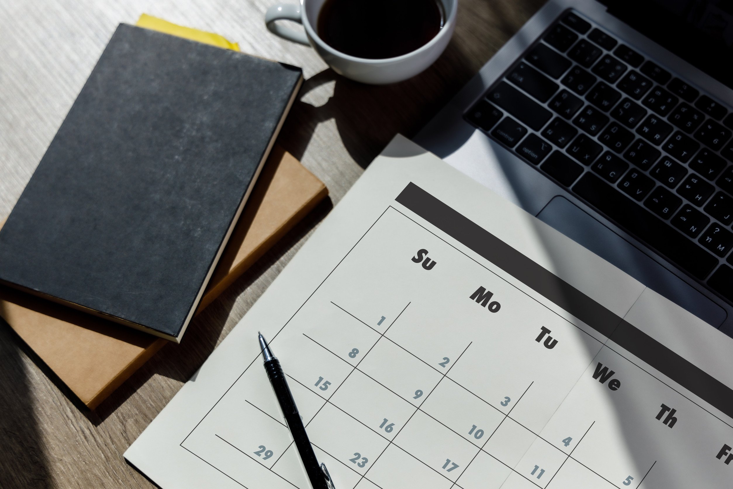 Tuloskalenteri 2026: Kuvituskuva, jossa on kalenteri, kynä, vihko ja kahvikuppi. Kuvassa näkyy myös tietokone.