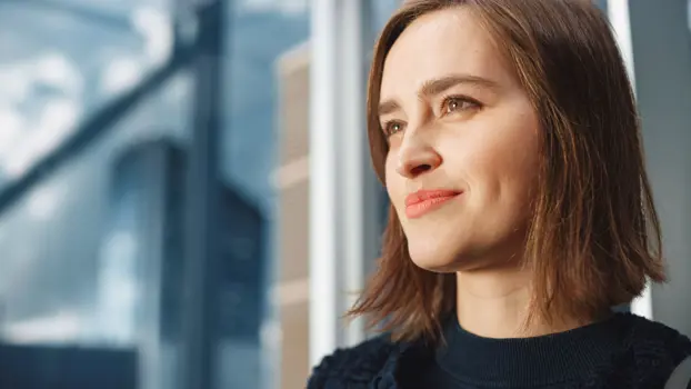 Lähikuva naisesta, joka katsoo kaukaisuuteen