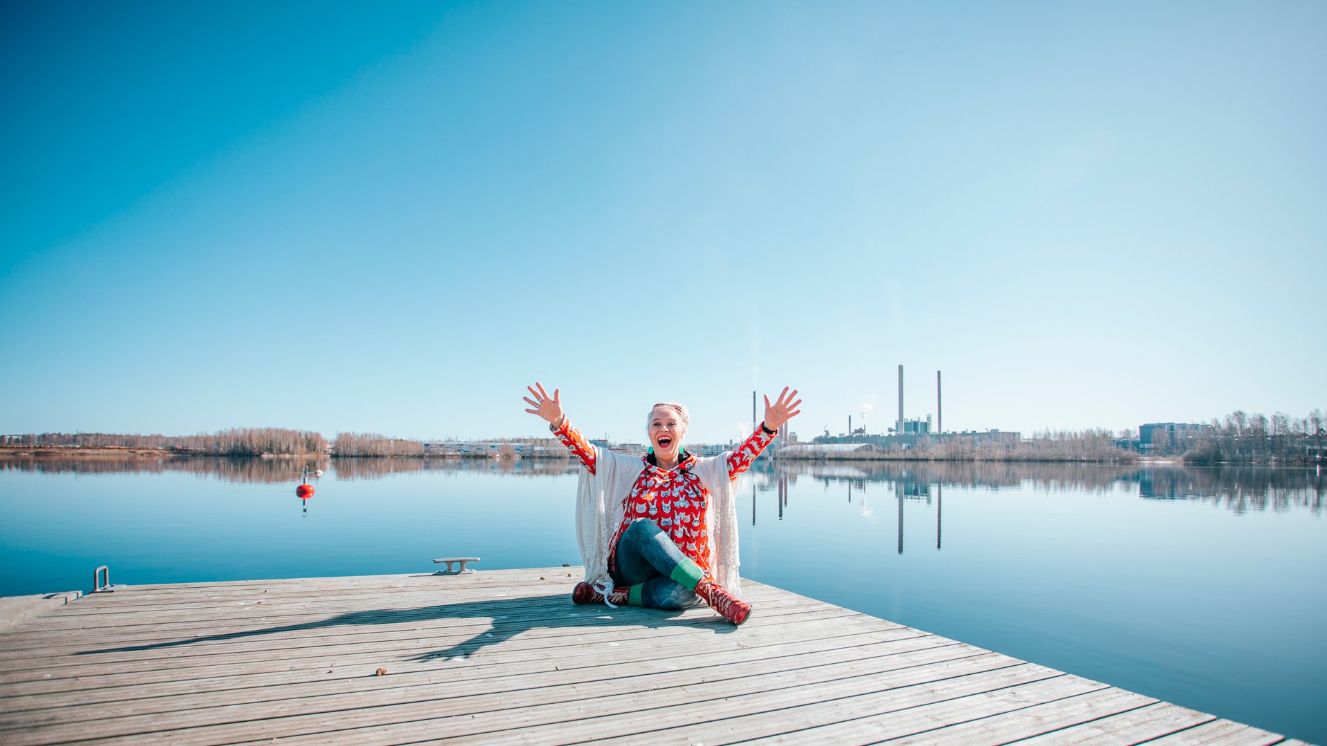 Ihminen istuu auringossa laiturilla