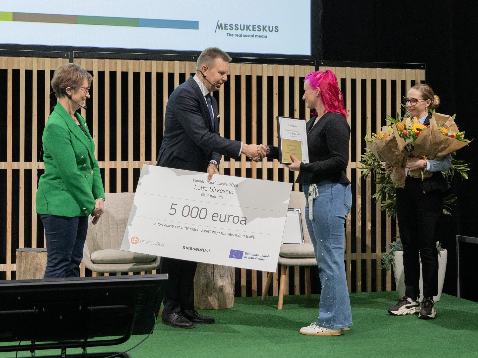 Harri Nummela ojentaa palkinnon Lotta Sirkesalolle.