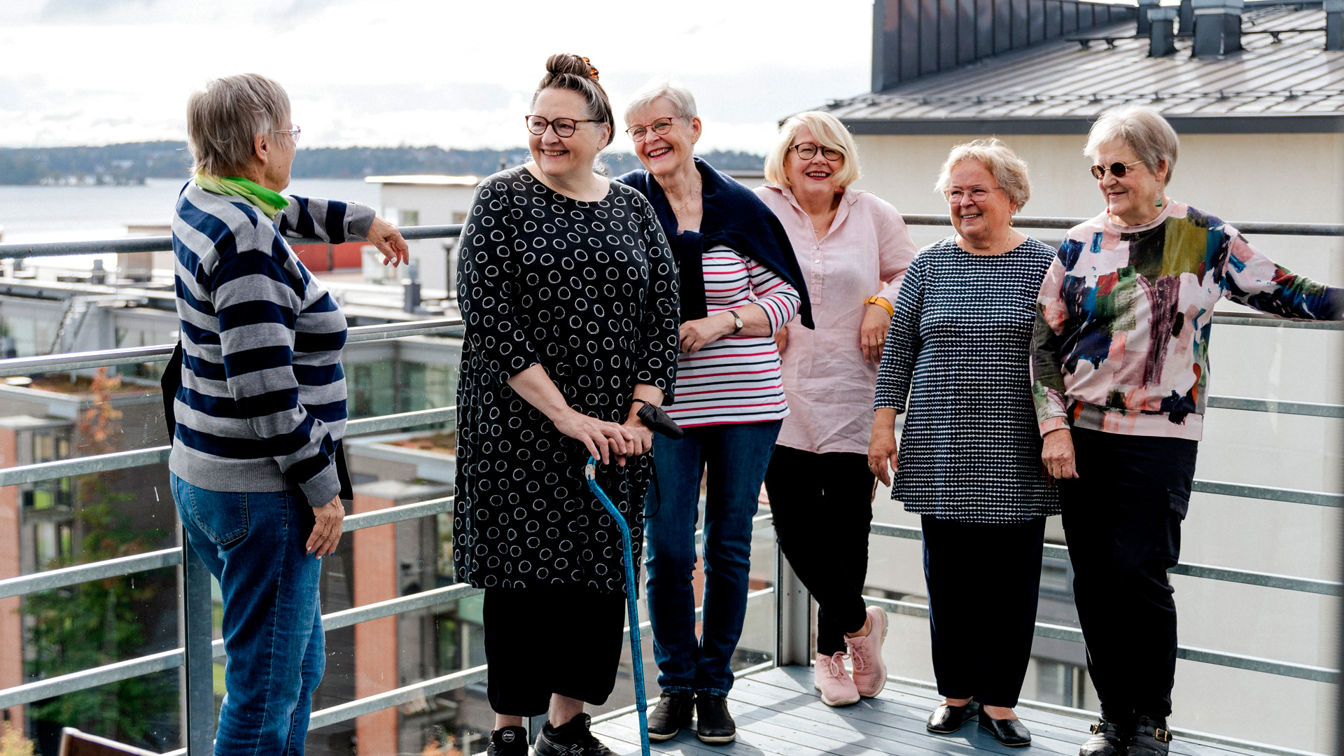 Yhteisöllisen senioritalon asukkaita kattoterassilla. Kuvassa kuusi varttunutta naista.