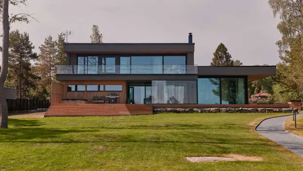 Suuren merenrantatontilla sijaitsevan talon merelle antava julkisivu.