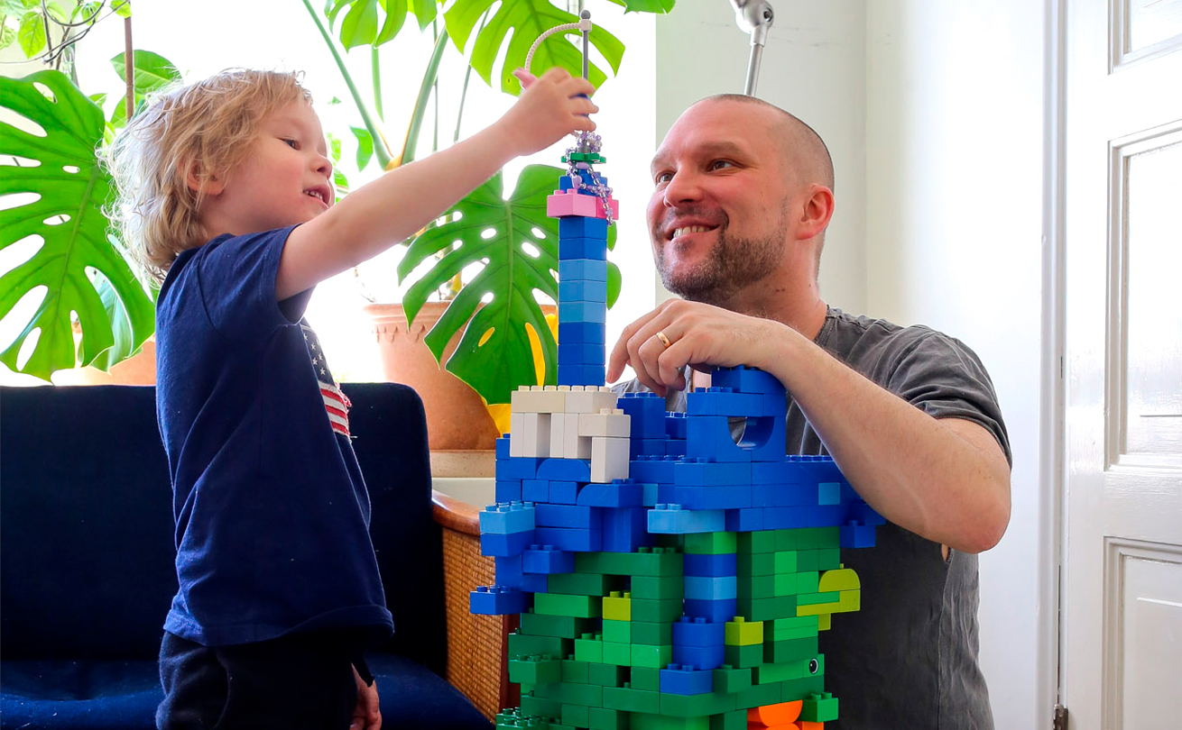Kuvassa isä Tommi Koivisto ja lapsi rakentamassa legoja.