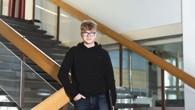 Veeti Herranen seisoo portaikossa käsi taskussa hymyillen.