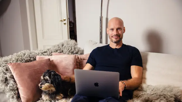 Kim Herold istuu kotinsa sohvalla kannettava tietokone edessään.