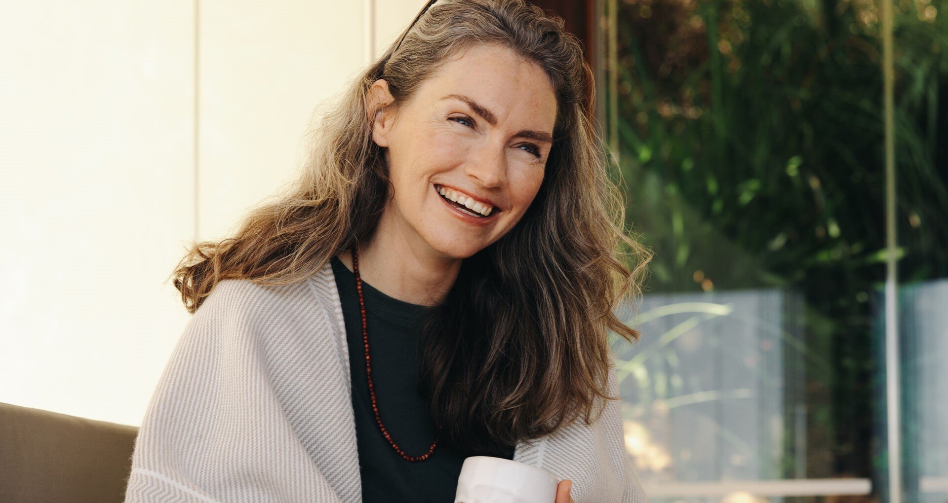 Nainen hymyilee kodissaan