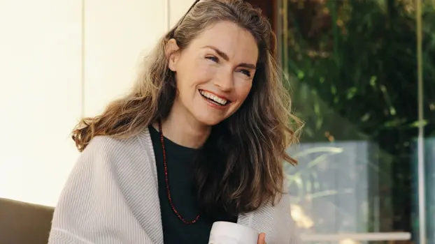 Nainen hymyilee kodissaan