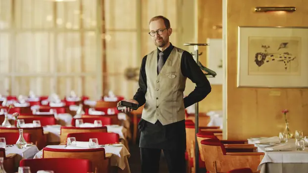 Tarjoilija Jami Järvinen seisoo työasussaan ravintola Lasipalatsin salissa.
