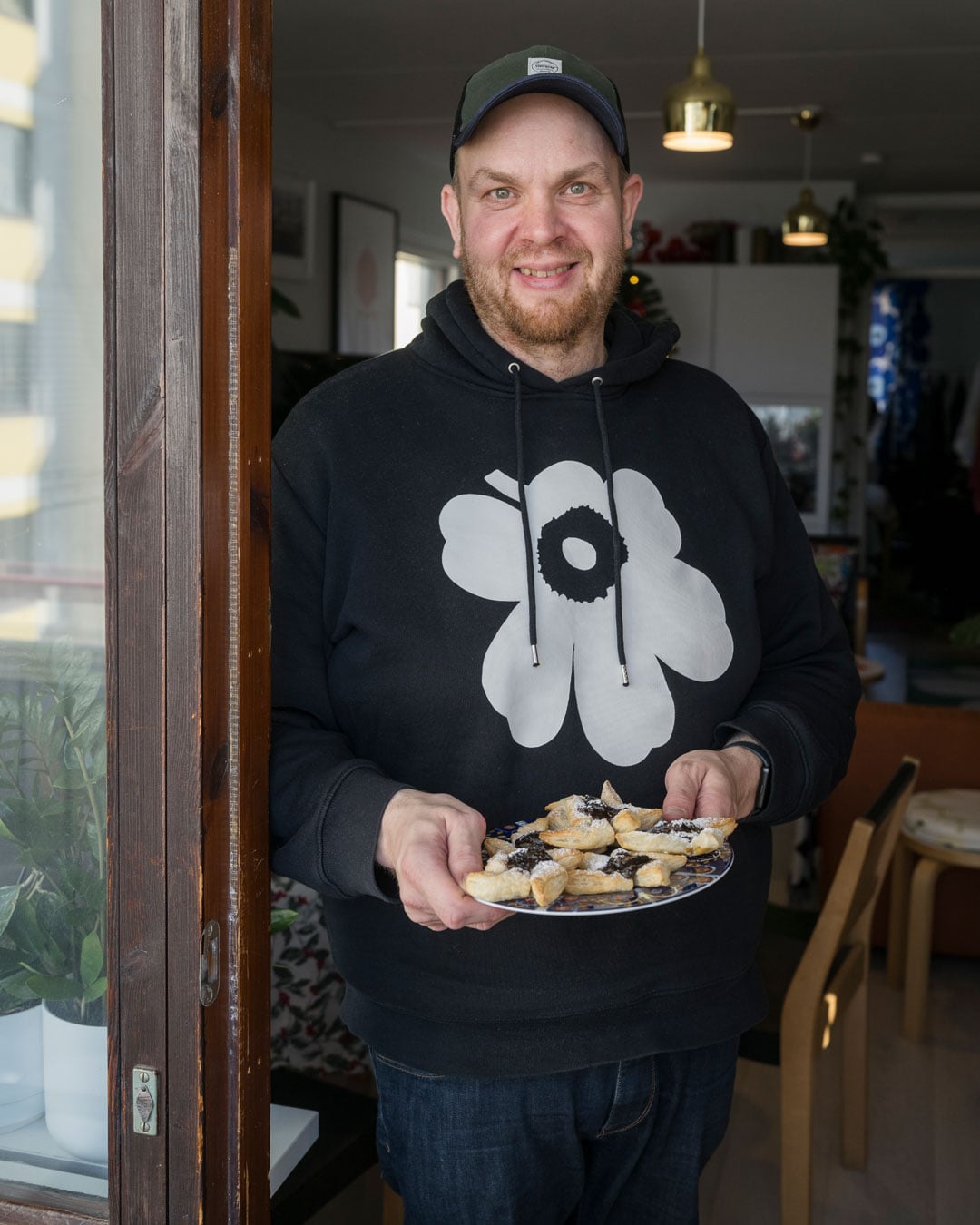 Pekka Laukkanen seisoo ovensuussa joulutorttulautanen käsissään.