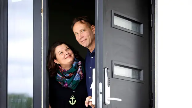Jukka ja Satu Juhola kurkistavat kotinsa ulko-ovesta ulos
