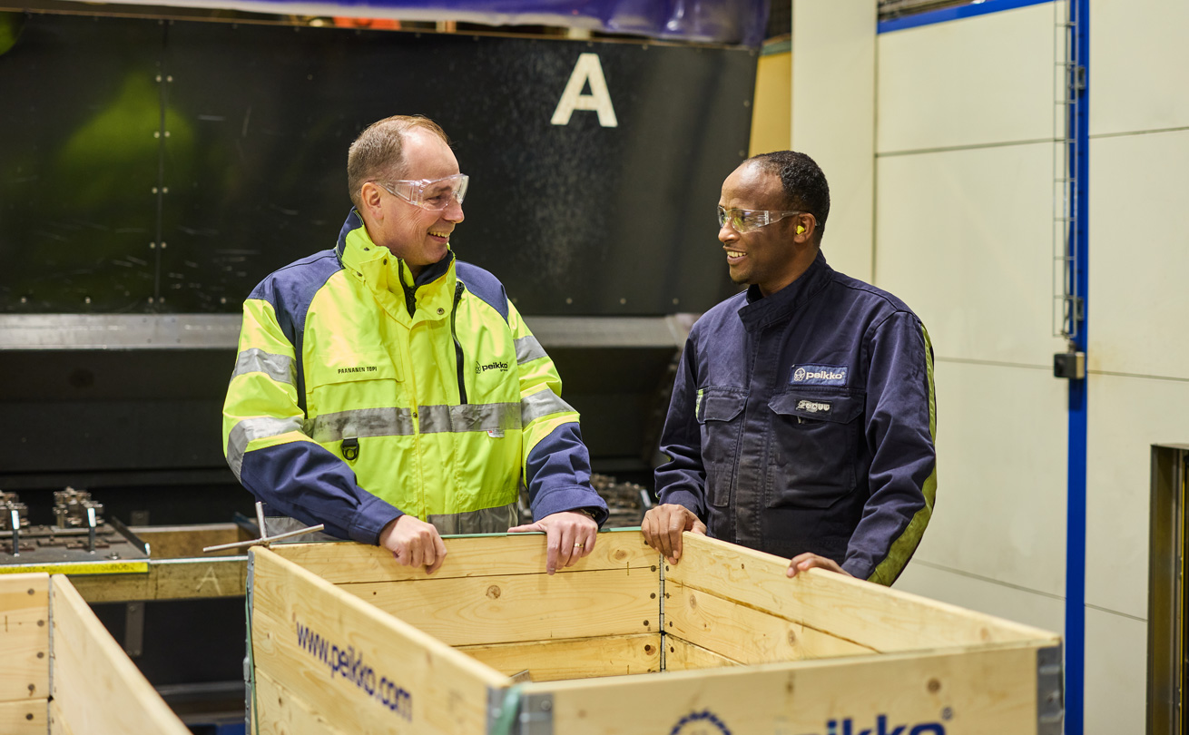 Topi Paananen työntekjiän kanssa kuljetuslaatikon äärellä