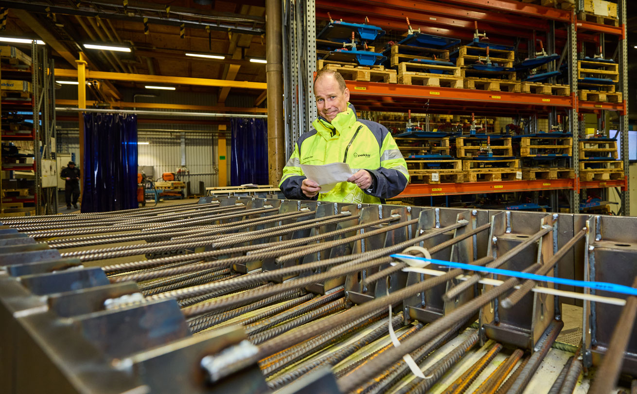 Topi Paananen tehtaalla terästuotteiden takana