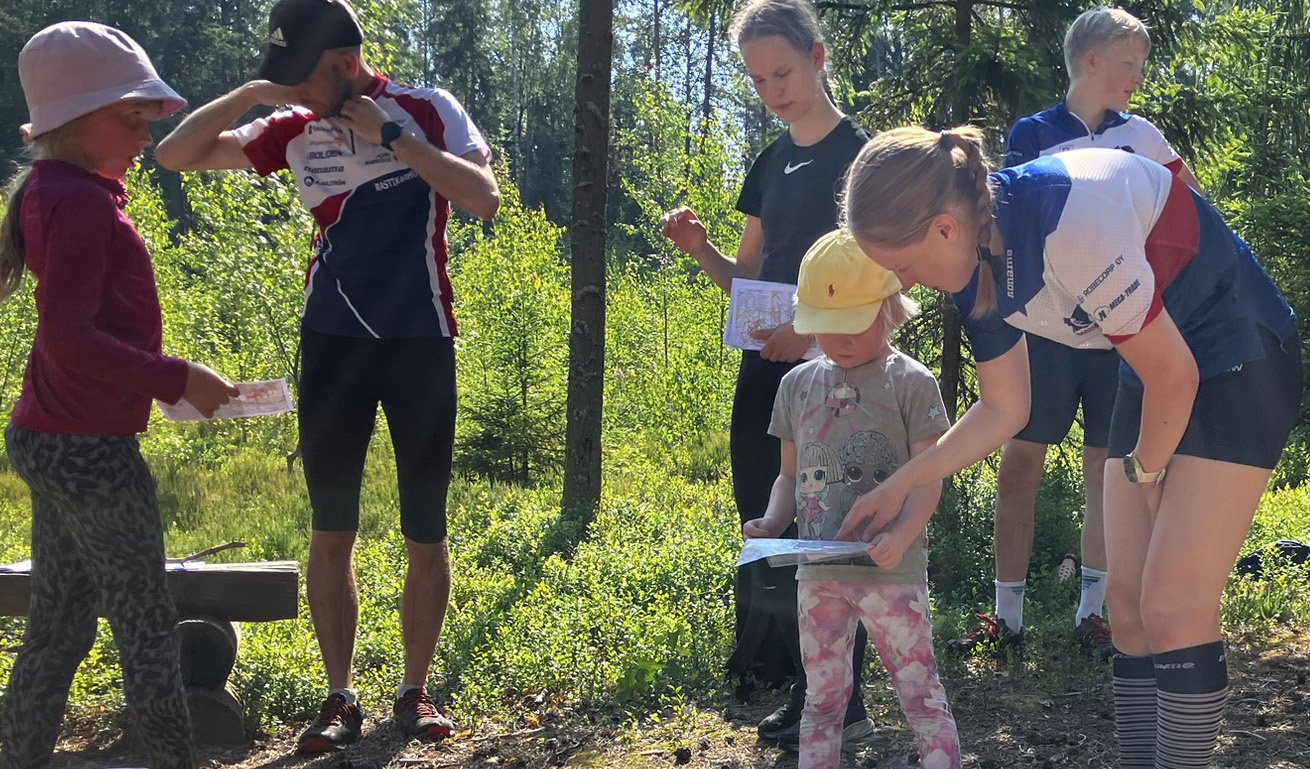 Ohjaaja opastaa pieniä leiriläisiä.