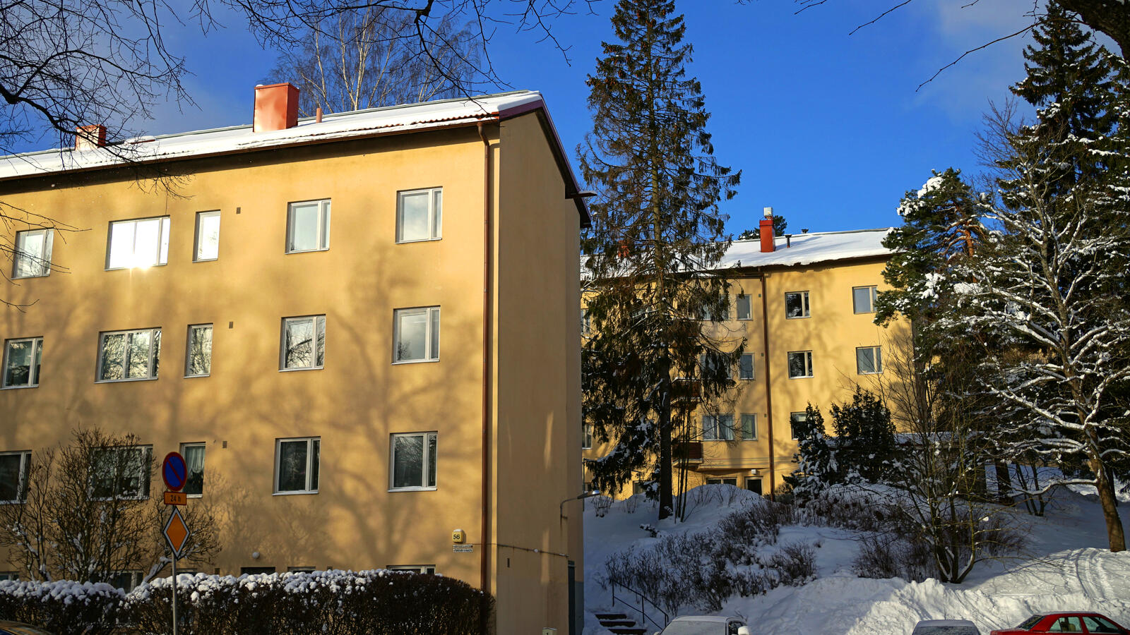 Keltaiset kerrostalot lumisessa maisemassa. 