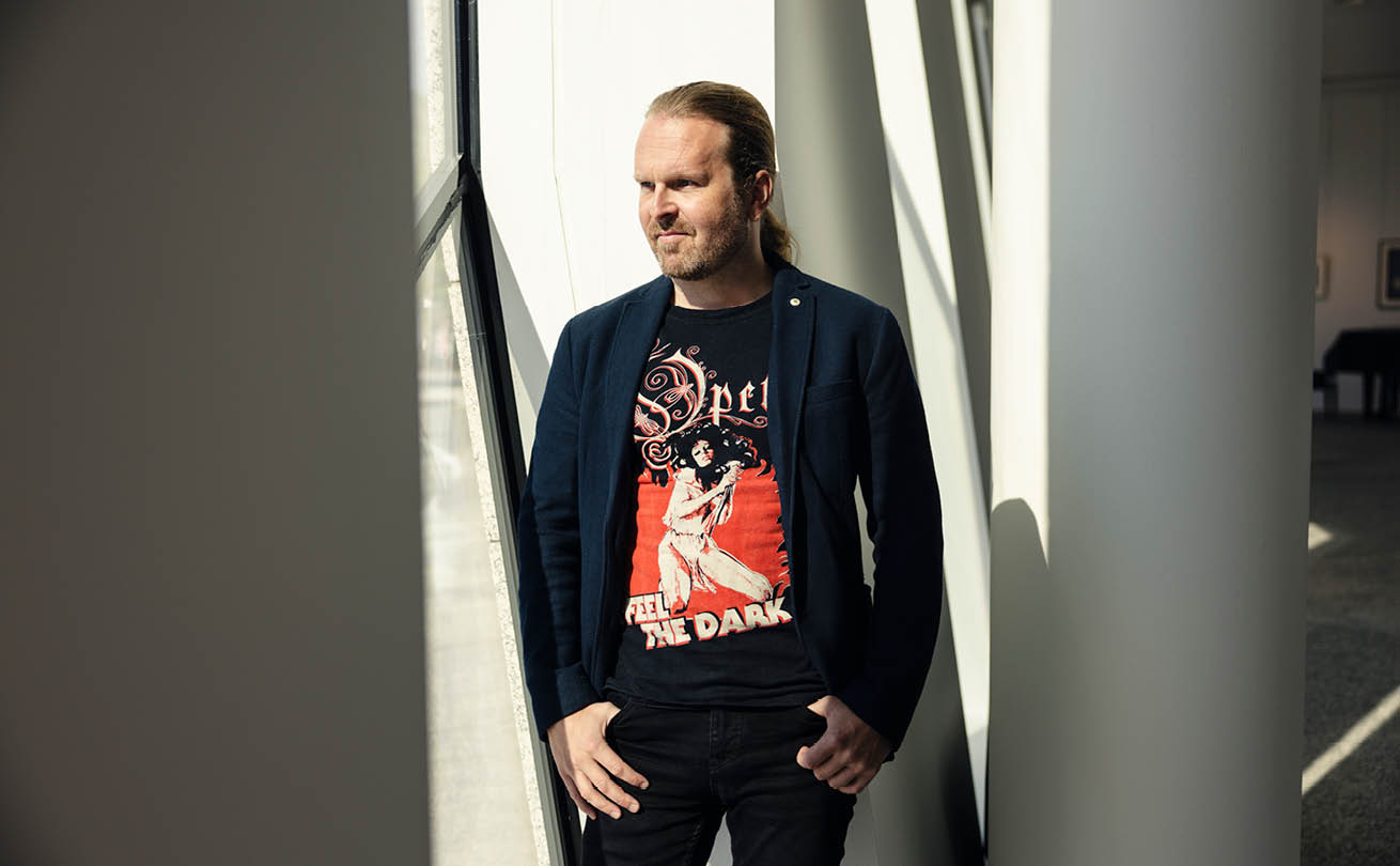 Ville Pekkala seisoo ja katsoo ulos ikkunasta OP-ryhmän pääkonttorin aulassa.